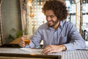 Man having glass of whisky in bar counter at bar