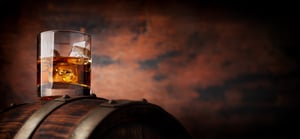 glass-of-whiskey-with-ice-cubes-on-the-old-barrel-2023-11-27-04-50-36-utc