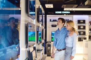 people in consumer electronics  retail store looking at latest laptop, television and photo camera to buy